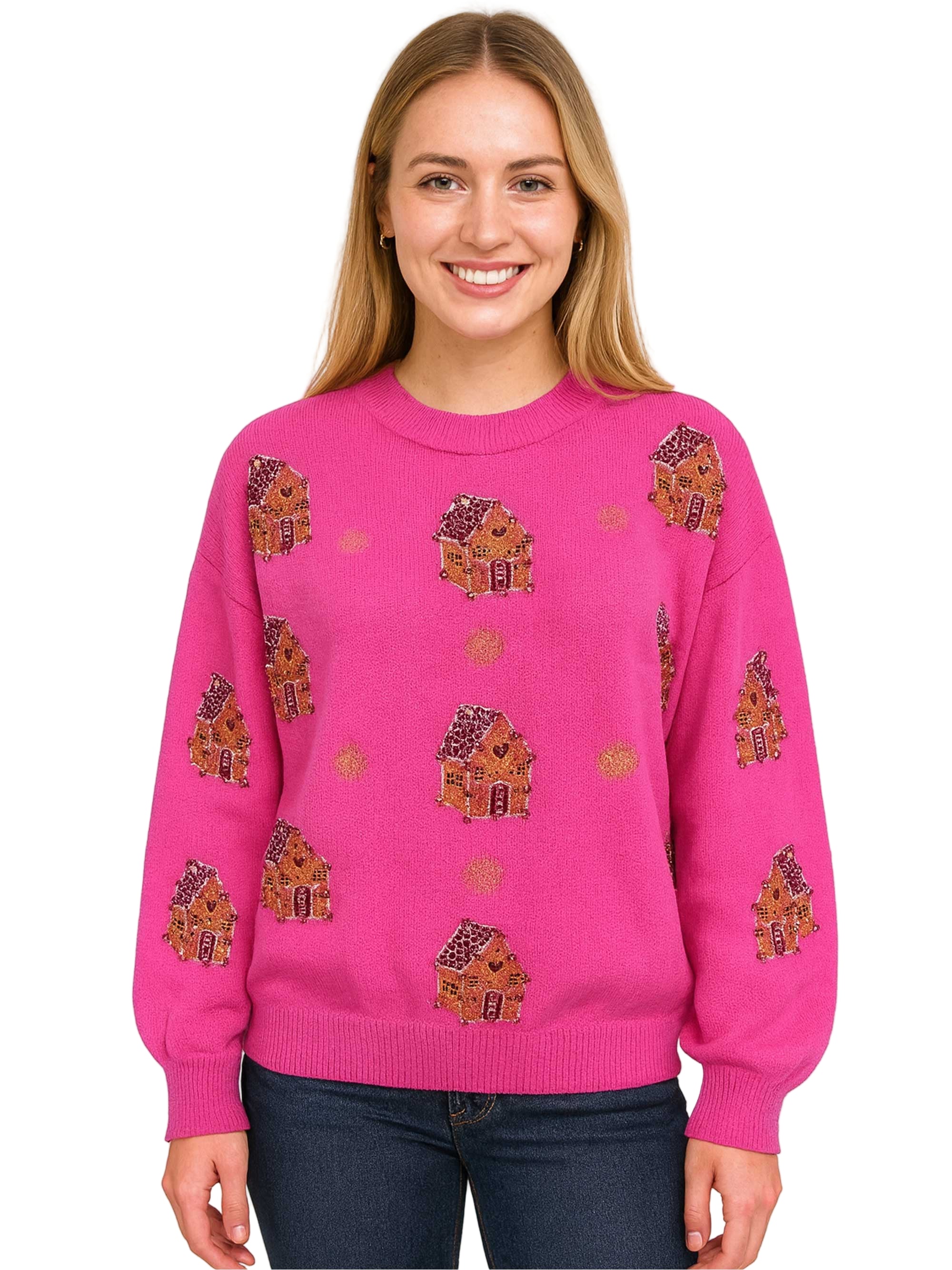 Woman wearing a pink sweater with gingerbread house patterns on a white background